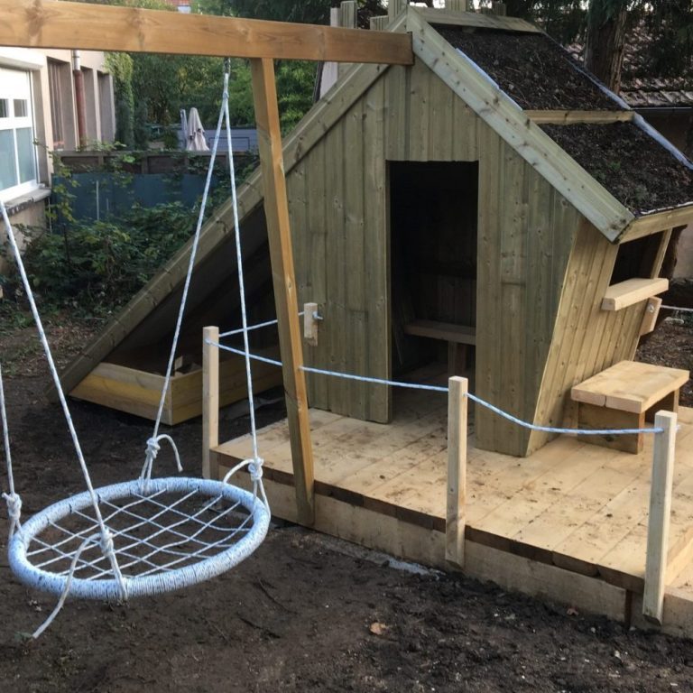 Cabane d'enfants en bois au toit végétalisé, avec terrasse et balançoire nid